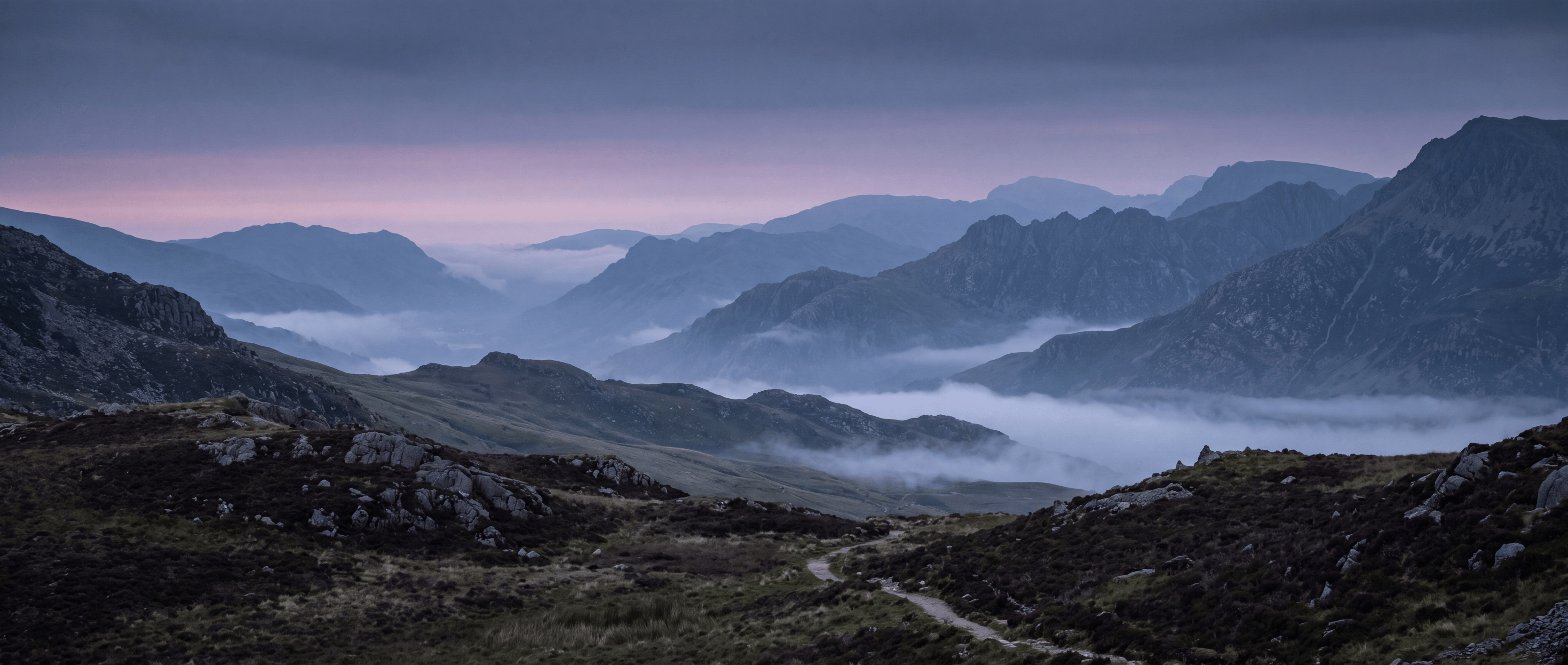 Welsh valleys under morning mist, a footpath winding through the heather